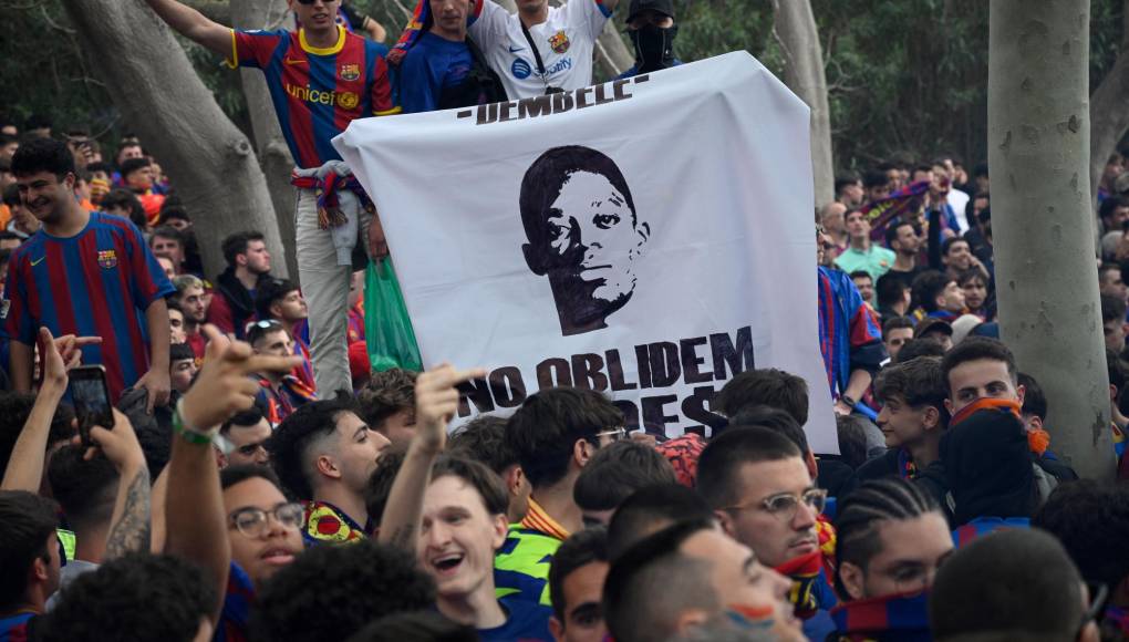 Los seguidores del Barcelona sostienen una pancarta que representa al delantero francés del Paris Saint-Germain, Ousmane Dembélé, y que dice “No olvidamos”.