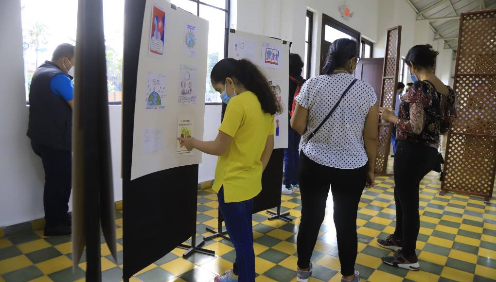 Una alumna de la Saint Peter Academy supervisa su arte en la exposición de dibujo.