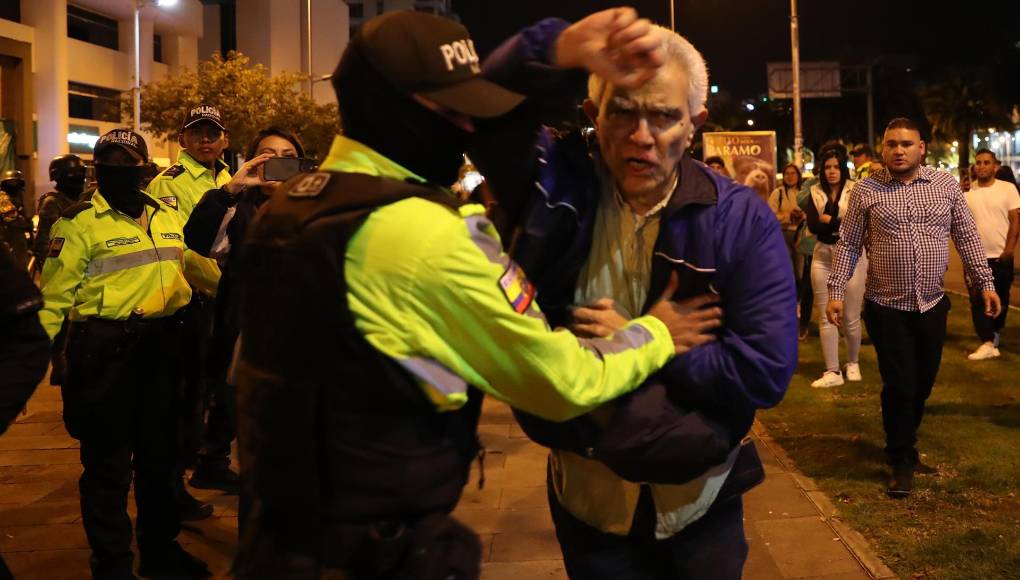 El jefe de Cancillería y Asuntos Políticos de la Embajada de México, Roberto Canseco, forcejea con policías para intentar evitar que trasladen al exvicepresidente Jorge Glas, condenado por corrupción. 