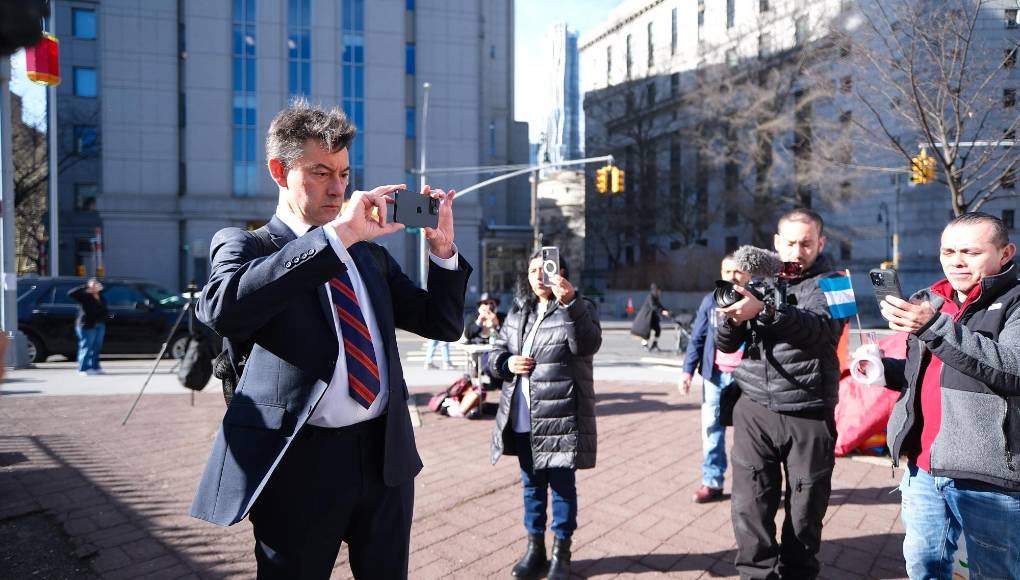 Antes de ingresar al edificio judicial, Stabile se detuvo un momento y sacó su celular para tomar fotografías y videos de los hondureños que protestan con pancartas frente a la Corte. 
