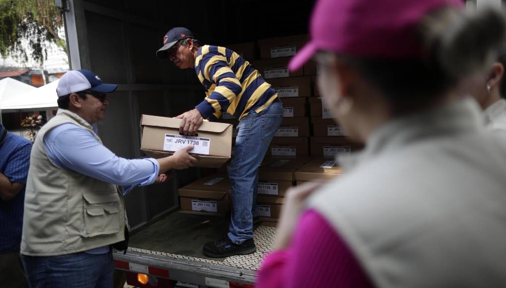 ES6001. EL SALVADOR 3/2/2024.- Personas descargan papeletas electorales en la avenida olímpica hoy durante los preparativos electorales en San Salvador (El Salvador). La inesperada lluvia con la que amaneció San Salvador complicó este sábado el reparto de las papeletas hacia los colegios electorales, destinadas a unos comicios el domingo en los que se espera que el presidente salvadoreño, Nayib Bukele, alcance una rotunda mayoría, algo que parece asimilar la oposición, que no se dejó ver en unos puntos de votación monopolizados por el azul y blanco del partido oficial Nuevas Ideas (NI). EFE/Bienvenido Velasco 