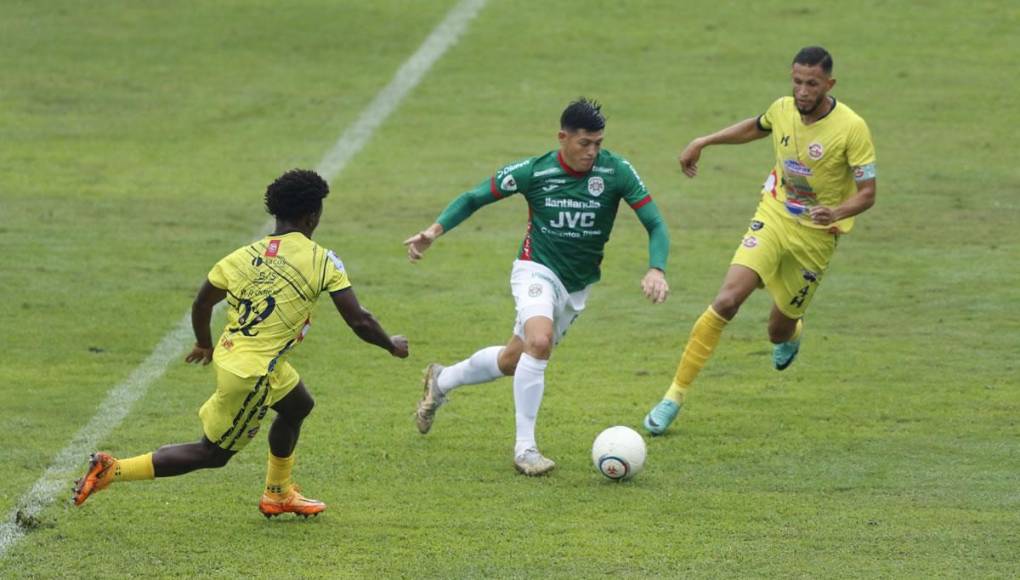 Francisco Martínez, conduciendo el balón entre dos futbolistas del Génesis.