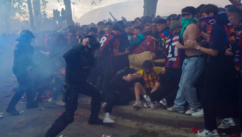 Seguidores del FC Barcelona se enfrentan a miembros de las fuerzas de seguridad antes del inicio del encuentro de vuelta. 