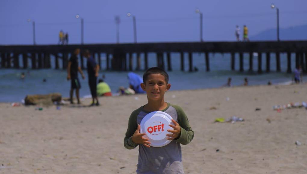 Un pequeño se alista para jugar con su disco cerca del muelle de Tela.
