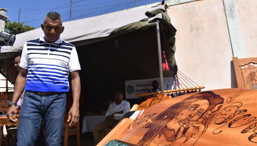 Marvin Alvarado Núnez, uno de los artesanos recluidos, posa junto a su obra de madera tallada con la imagen del extinto cantante jamaiquino, Bod Marley. Son unos 25 privados que se dedican a la madera.