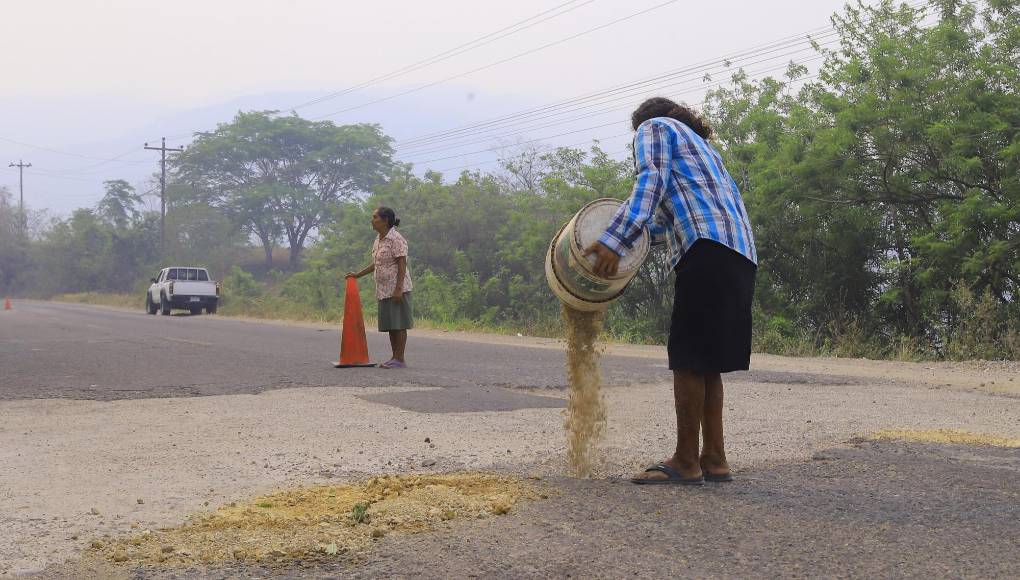 <b>A lo largo de la ruta se encuentran alguna s persona que viven de tapar agujeros, como la señora María Amaya, su hija Alba Luz y su nieta Dulce María de apenas seis años, quienes todos los días se trasladan desde Santa Rita a buscar hoyos en la carretera RN-23 que conduce a la cabecera. </b>