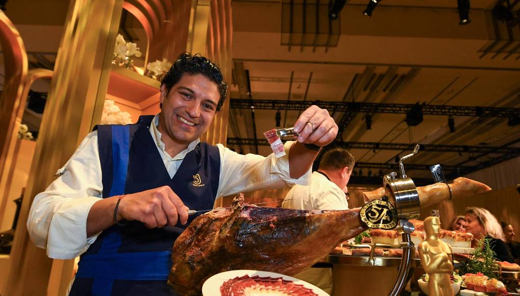 En la imagen, Raúl Garrido, cortador de jamón de la firma Cinco Jotas, con una de las patas de la firma durante la presentación del menú de los Oscar. El jamón de bellota 100 % ibérico se ha vuelto “uno de los favoritos” entre los asistentes, pero sobre todo de Puck, quien para esta ocasión mandó pedir diez piezas de jamón para poder saciar la demanda de la gente. “Mientras tengamos a un buen maestro cortador, vamos a tener jamón ibérico”, aseguró Puck. 