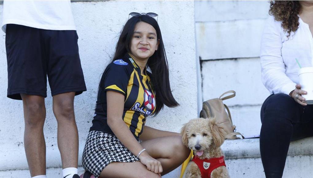 La linda joven y el canino en el sector de preferencia del estadio Olímpico. 