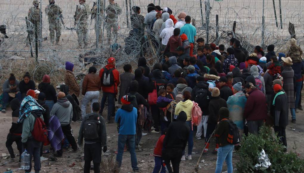 Migrantes tratan de cruzar las vallas fronterizas, el 20 de marzo de 2024, en Ciudad Juárez. 