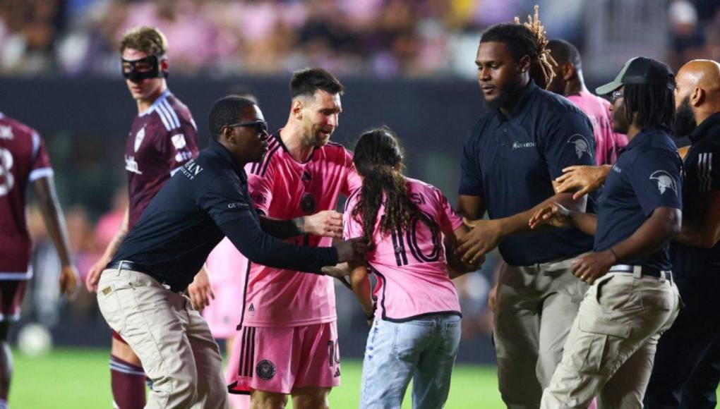Momento en donde los elementos de seguridad se llevaban a la joven que se tomó una fotografía con Leo Messi.