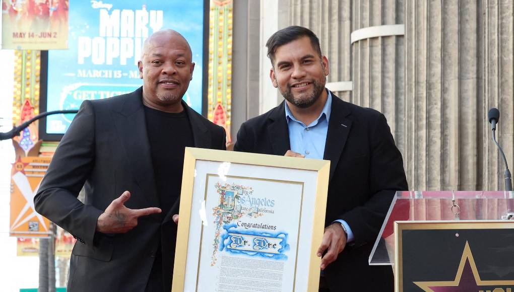 “Las contribuciones del Dr. Dre a la industria musical son innegables y han dejado una marca indeleble en la cultura popular. Como productor, rapero y empresario, el Dr. Dre ha superado continuamente los límites y establecido nuevos estándares de excelencia. Es un gran orgullo honrar su increíble carrera y su extraordinario impacto otorgándole una estrella en el Paseo de la Fama. “La estrella del Dr. Dre servirá como un símbolo duradero de su inmenso talento y legado perdurable en el mundo de la música”, afirmó Ana Martínez, Productora del Paseo de la Fama de Hollywood. “Lo especial de la ubicación elegida para la estrella de Dr. Dre es que estará al lado de la estrella de su larga trayectoria. ¡Amigo del tiempo, Snoop Dogg!”, agregó Martínez, En la foto aparece .Dr. Dre y Hugo Soto-Martínez , director de la ceremonia de las estrellas del Paseo de la Fama de Hollywood.