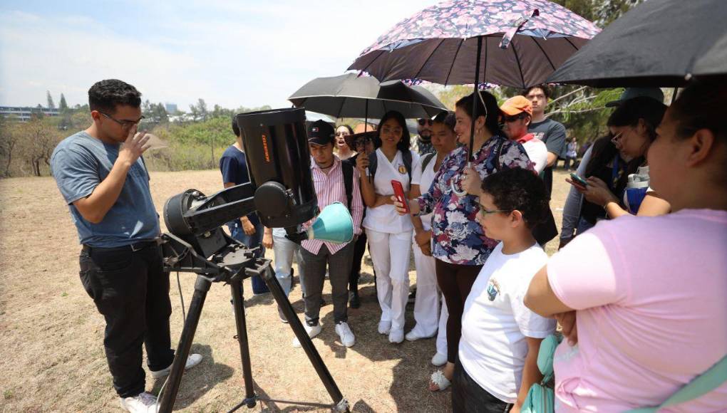 Uno de los estudiantes le explica los demás el procesimiento para ver el eclipse desde el observatorio de la UNAH.