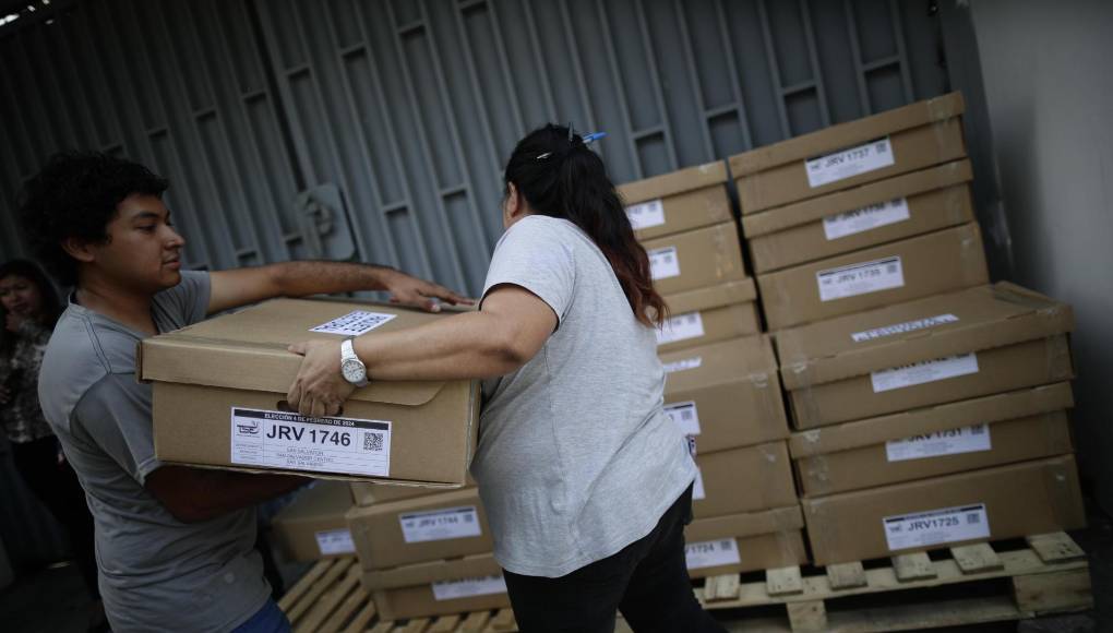 AME5104. SAN SALVADOR (EL SALVADOR), 03/02/2024.- Personas descargan papeletas electorales en la avenida olímpica hoy durante los preparativos electorales en San Salvador (El Salvador). La inesperada lluvia con la que amaneció San Salvador complicó este sábado el reparto de las papeletas hacia los colegios electorales, destinadas a unos comicios el domingo en los que se espera que el presidente salvadoreño, Nayib Bukele, alcance una rotunda mayoría, algo que parece asimilar la oposición, que no se dejó ver en unos puntos de votación monopolizados por el azul y blanco del partido oficial Nuevas Ideas (NI). EFE/Bienvenido Velasco 