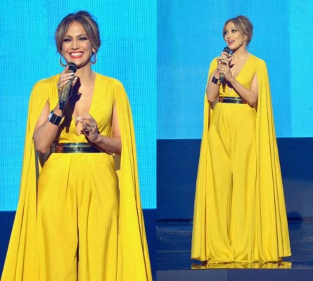 A Jennifer Lopez no le asustan las supersticiones y la cantante eligió este mono 'palazzo' de color amarillo de con capa de Michael Costello, uno de los estilismos más sofisticados de la noche.