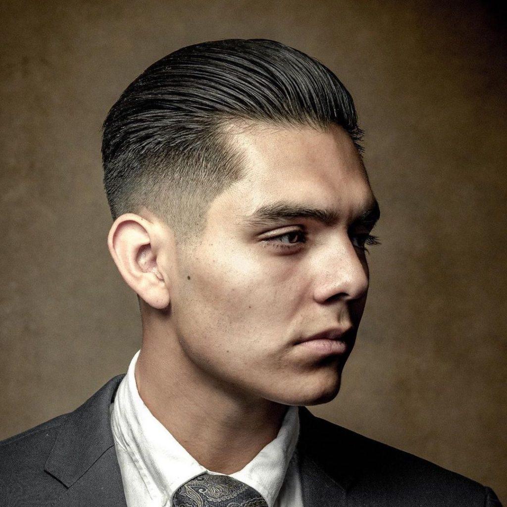 Peinado hacia atrás: el cabello peinado hacia atrás siempre será genial. Simplemente pida un corte de pelo clásico de hombre de longitud media en la parte superior con flequillo más largo y lados cortos o el desvanecimiento de su deseo. Puede hacerlo con el pelo húmedo o seco. Solo toma un poco de crema para peinar, pásela por el cabello con los dedos o peine con un peine. Las pomadas o gel con brillo le darán un aspecto húmedo. Las pomadas de acabado mate se verán naturales.