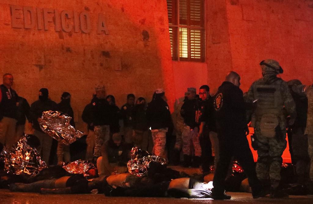Firefighters and Mexican soldiers rescue migrants from an immigration station in Ciudad Juarez, Chihuahua state on March 27, 2023, where at least 39 people were killed and dozens injured after a fire at the immigration station. (Photo by HERIKA MARTINEZ / AFP)