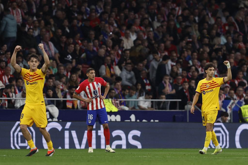 Barcelona's Portuguese forward #14 Joao Felix (R) celebrates scoring the opening goal during the Spanish league football match between Club Atletico de Madrid and FC Barcelona at the Metropolitano stadium in Madrid on March 17, 2024. (Photo by OSCAR DEL POZO / AFP)