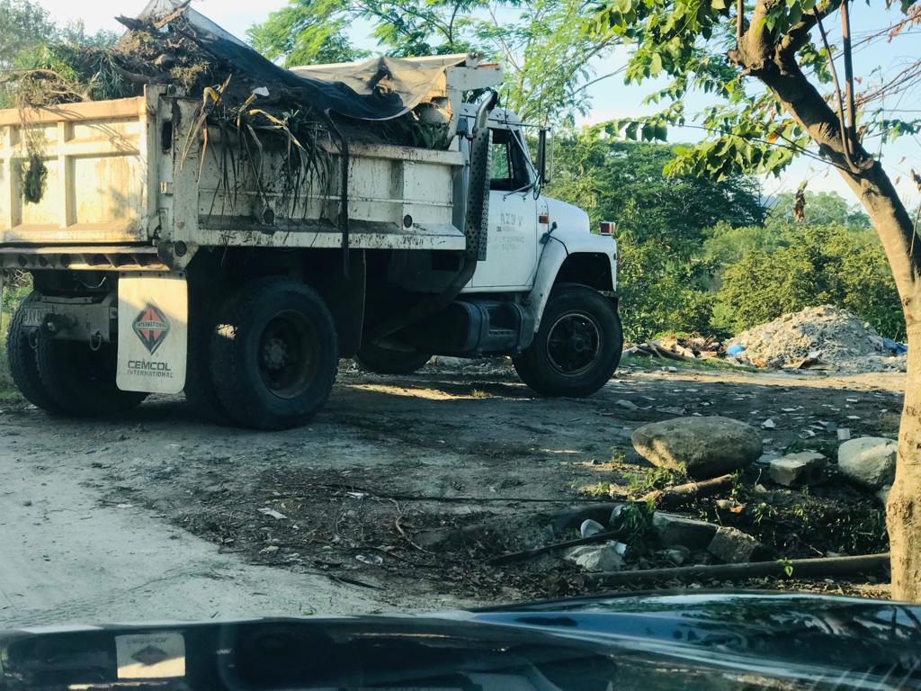 Una volqueta tira ripio en un río de San Pedro Sula.