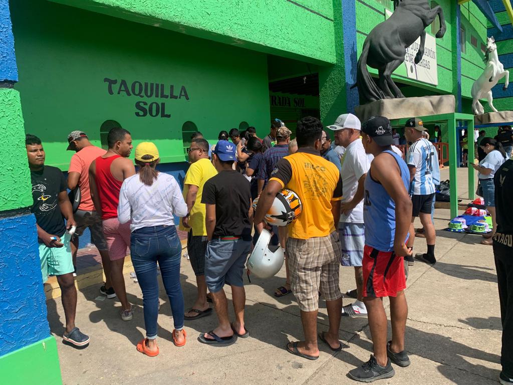 Aficionados haciendo filas en la taquilla para adquirir un boleto.