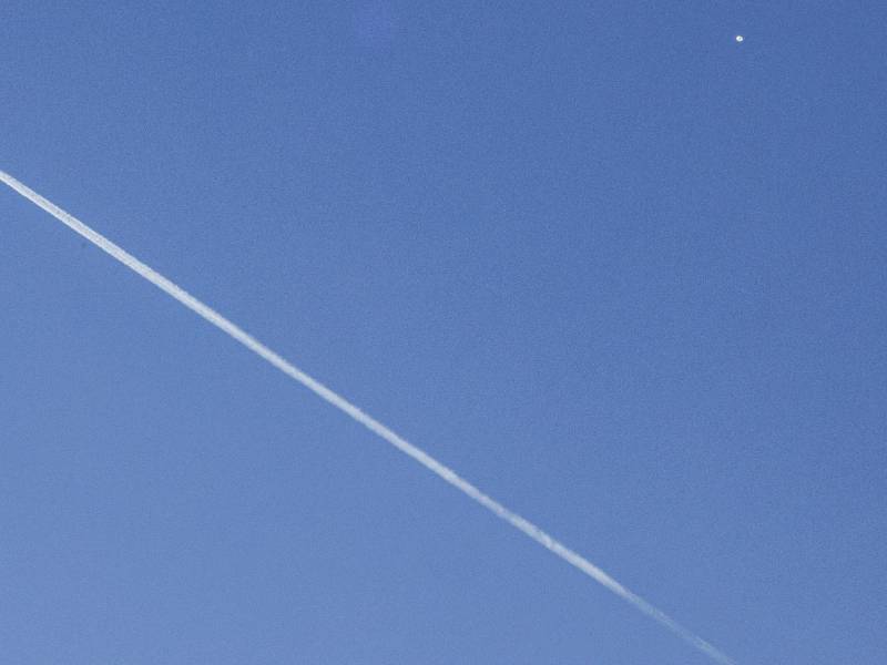 Un avión comercial (i) vuela por debajo del globo espía chino (d) detectado en el espacio aéreo estadounidense, este sábado en Charlotte (Estados Unidos).