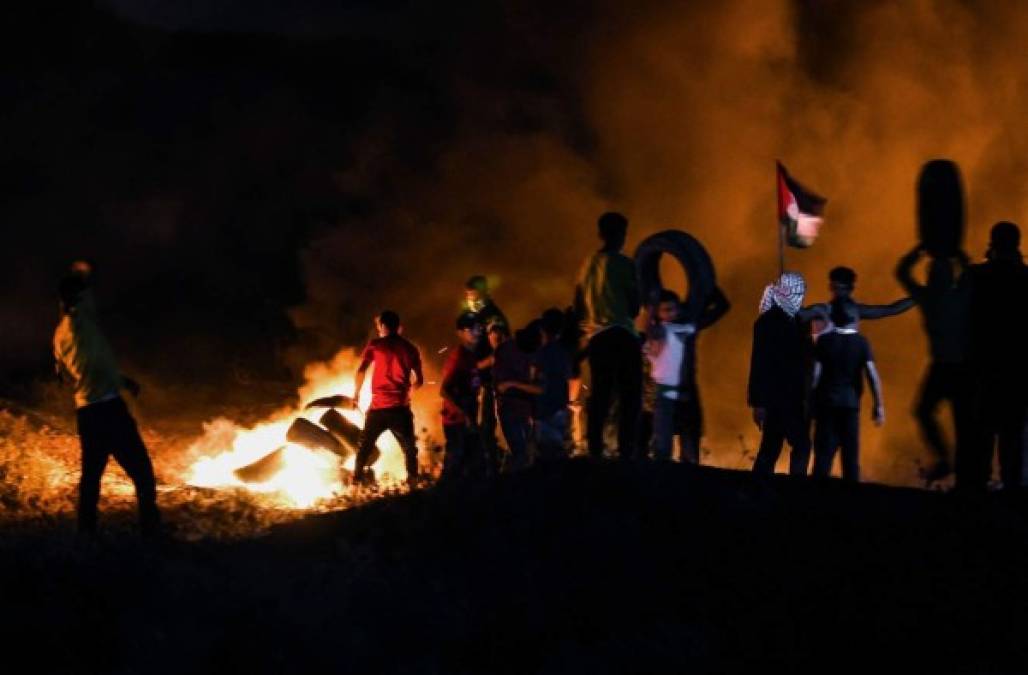 Palestinian protesters burn tyres during a demonstration east of Gaza City by the border with Israel, on June 15, 2021, to protest the Israeli ultranationalist March of the Flags in Jerusalem's Old City which celebrates the anniversary of Israel's 1967 occupation of Jerusalem's eastern sector. (Photo by Mahmud hams / AFP)