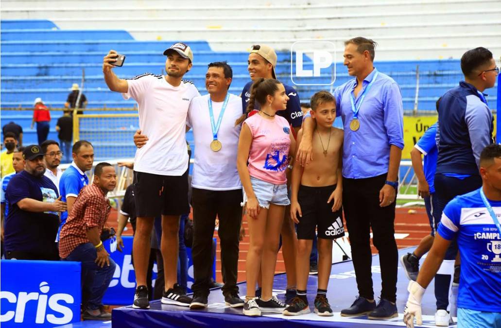 ‘La Tota‘ Medina recibió la medalla de campeón acompañado por sus hijos.