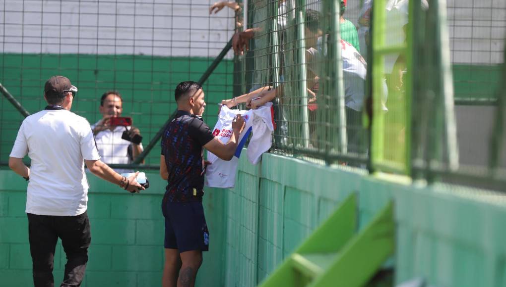 ”Choloma” López firman la camisa de un aficionado.