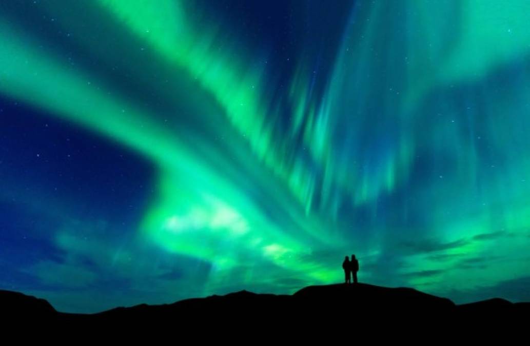 Finlandia (4)<br/><br/>¿Te fascinan las auroras boreales? Finlandia es de los países más populares de Europa en presenciar estos espectáculos naturales. Por supuesto que un hondureño podría visitar este país con tan solo presentar su pasaporte en el aeropuerto internacional. <br/>Aurora borealis with silhouette love romantic couple on the mountain.Honeymoon travel concept