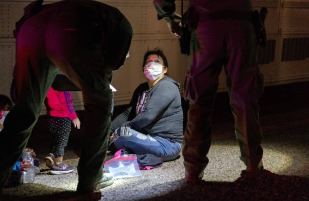 Una familia de inmigrantes espera a que los agentes de la Patrulla Fronteriza de los Estados Unidos los transporten a un centro de procesamiento en Texas. AFP