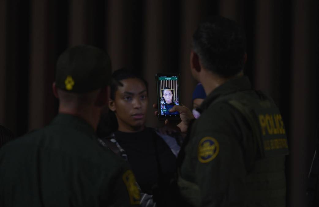 Los agentes fronterizos revisan los pasaportes de las personas recién llegadas y se los llevan detenidos para estudiar sus solicitudes de asilo.