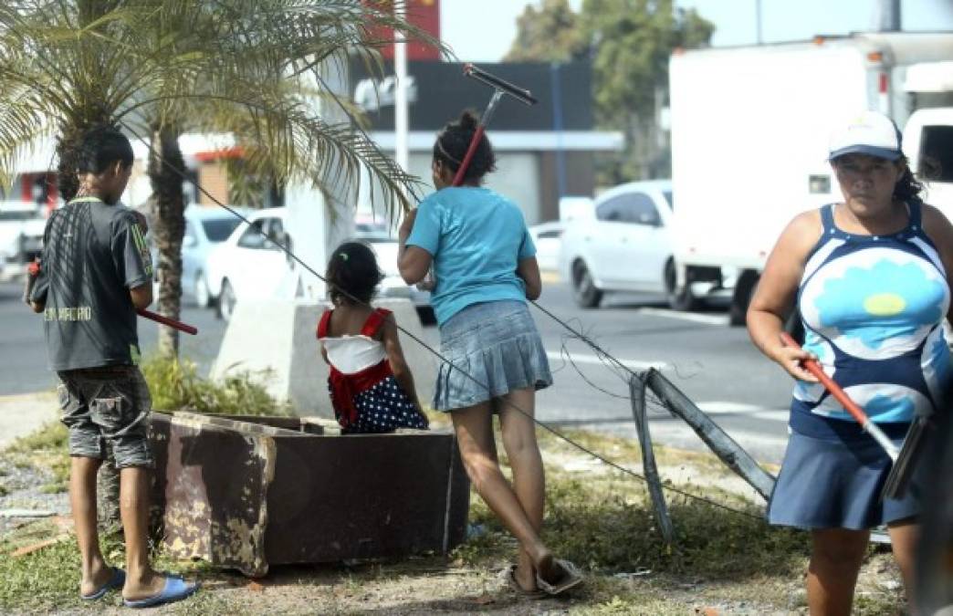 Los adultos vigilan de cerca a los menores, ya que son ellos quienes se quedan con todo el dinero que recogen, tal como se observa en la imagen tomada por Diario LA PRENSA.