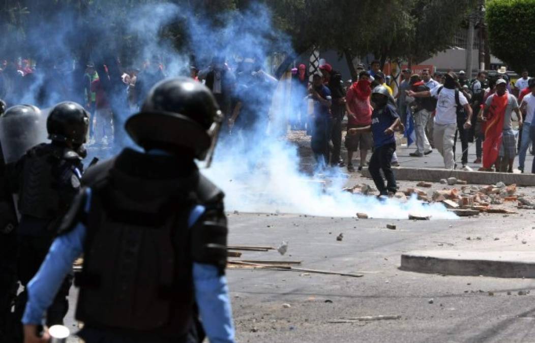 Supporters of the Libertad y Refundación (LIBRE) party holding a protest against the Independence anniversary celebrations, clash with riot police and Army soldiers, at the Morazan boulevard, in Tegucigalpa, on September 15, 2019. (Photo by ORLANDO SIERRA / AFP)
