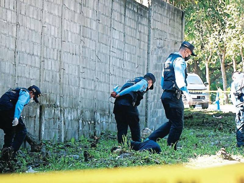 Policías inspeccionan una escena del crimen | Fotografía de archivo