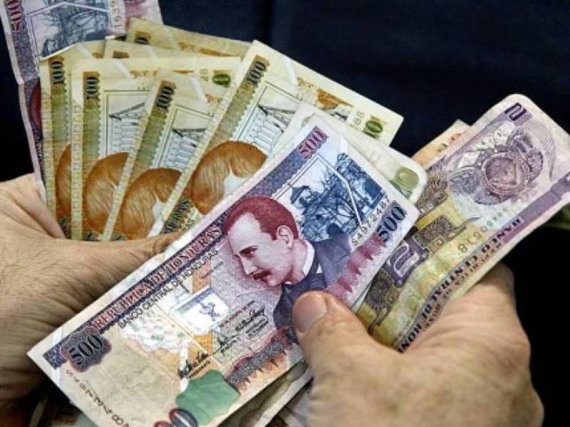 Billetes de 500, 100 y dos lempiras en las manos de un hondureño.