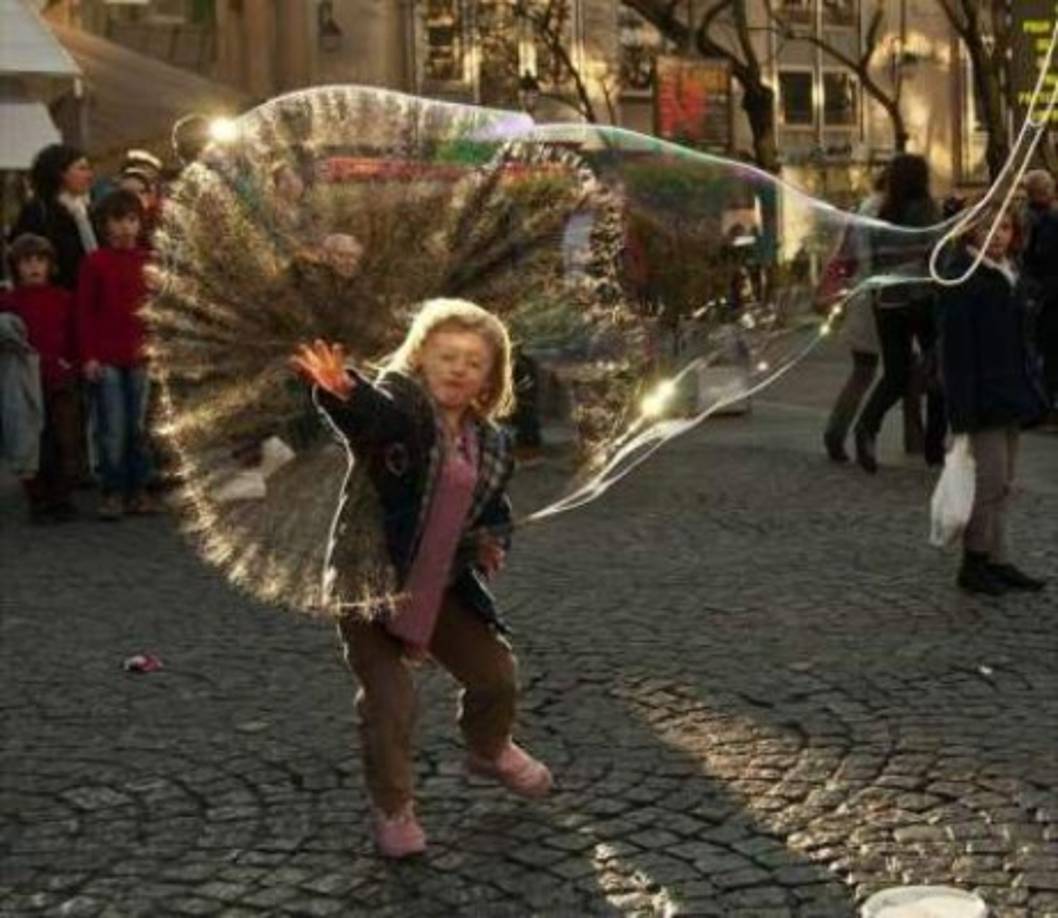 Un niño juega con una burbuja gigante.