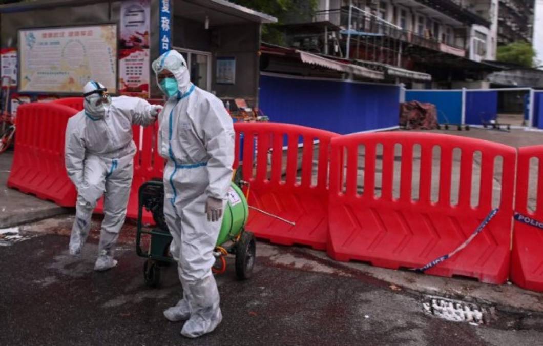 A vendor, wearing a face mask as a preventive measure against the spread of the COVID-19 novel coronavirus, waits for customers at her meat stall in Wuhan, China's central Hubei province on April 20, 2020. - China's economy shrank for the first time in decades last quarter as the coronavirus paralysed the country, in a historic blow to the Communist Party's pledge of continued prosperity in return for unquestioned political power. (Photo by Hector RETAMAL / AFP)