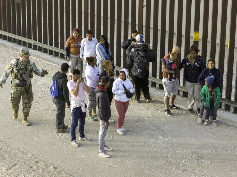 Un grupo de migrantes es vigilado por la Guardia Nacional tras ingresar a Texas.