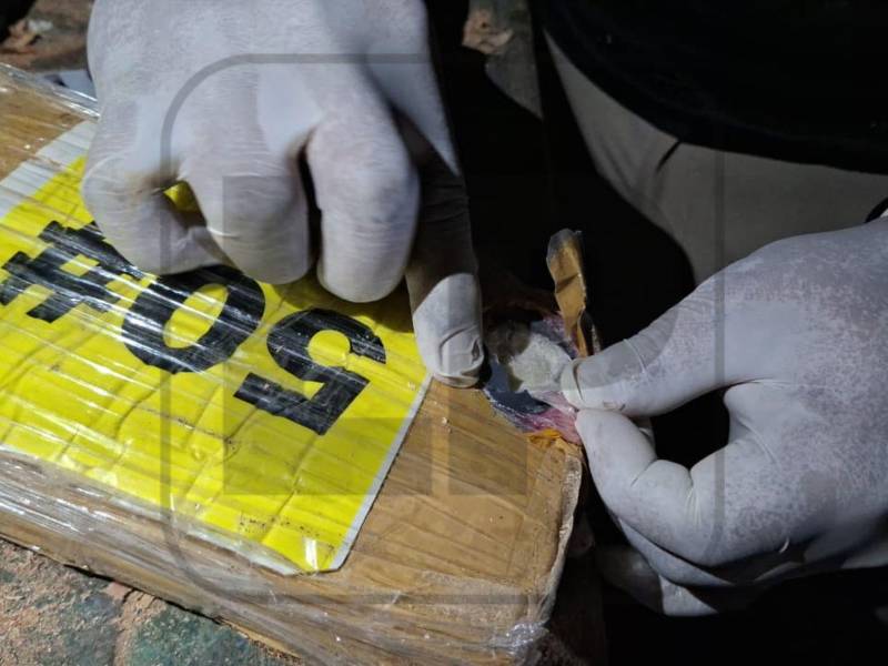 La imagen muestra uno de los paquetes seleccionados aleatoriamente durante el operativo, que reaccionó con el característico color azul en las pruebas realizadas tras el decomiso.