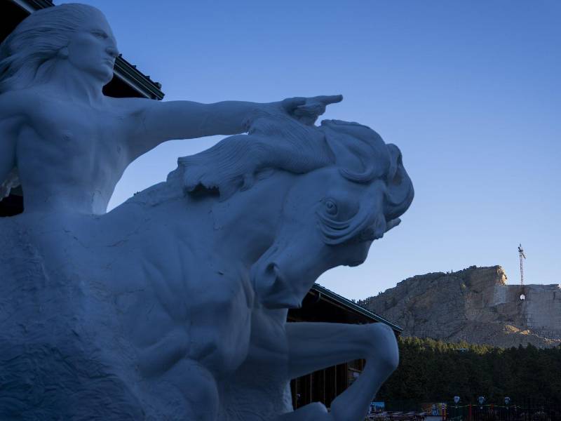 La estatua en el centro de visitantes del Monumento a Caballo Loco es el modelo de la escultura a lo lejos.