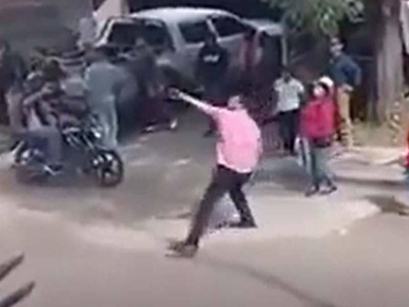 Momento en el que el diputado de Libre, Mauricio Rivera, lanza una piedra al edificio de Ciudad Mujer en Tegucigalpa.