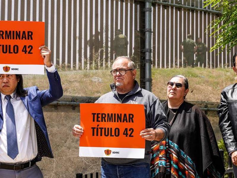 Unas personas sostienen pancartas del Consorcio de Derechos de los Inmigrantes de San Diego (SDIRC) que piden poner fin al Título 42 en San Diego, California.