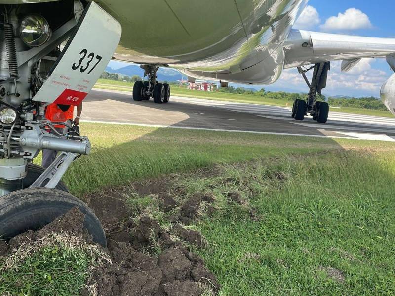 La aeronave Airbus A330 aún está estancada en la grama adyacente a la pista.