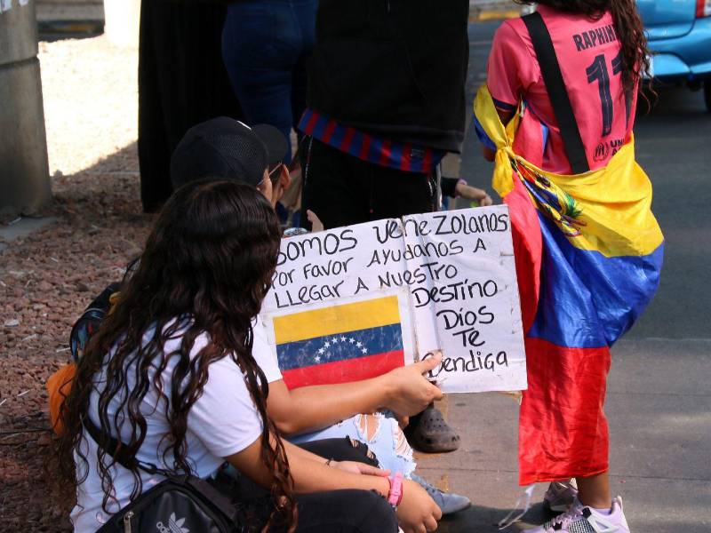 Niños y adultos venezolanos se sientan en semáforos de Honduras, solicitando ayuda mientras buscan continuar su viaje o establecerse temporalmente en el país.