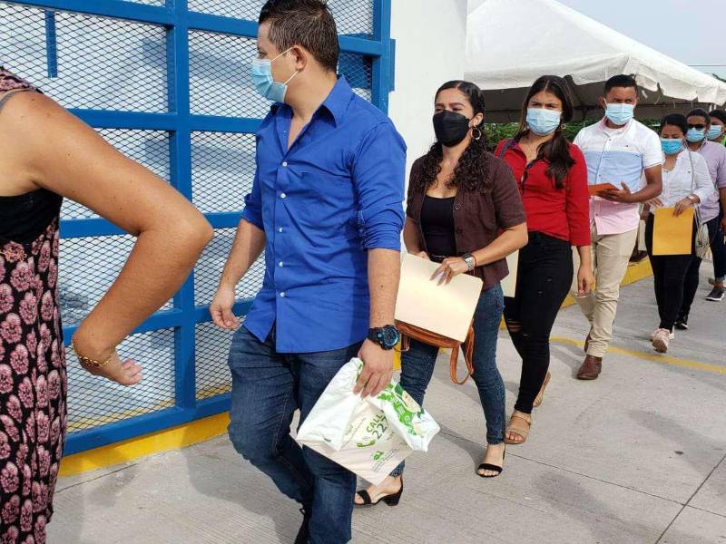 Jóvenes hondureños hacen fila para buscar trabajo en una feria de empleo.