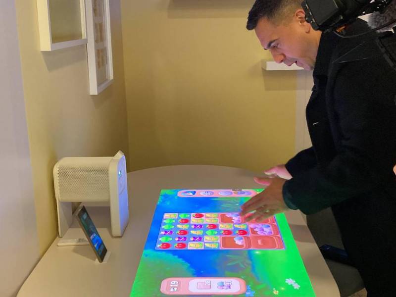 Un usuario se divierte con un juego que se proyecta en una mesa con The Premiere 5, en el evento First Look, de Samsung.