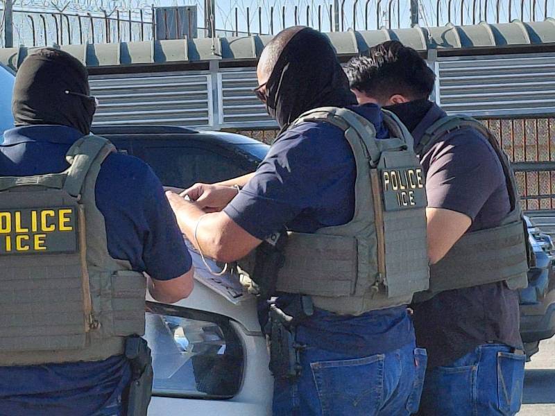 Agentes de ICE revisan documentación de migrantes detenidos.