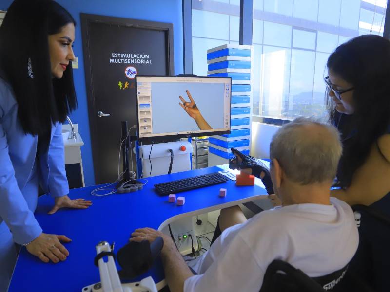 Un paciente en CREA recibe terapia con el R-Touch, que es un guante robótico diseñado para la rehabilitación y recuperación funcional de la mano.