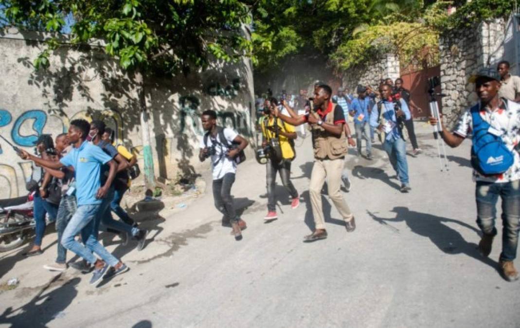 Miembros de la prensa corren detrás de la ambulancia que traslada el cuerpo del asesinado presidente haitiano, Jovenel Moise. EFE