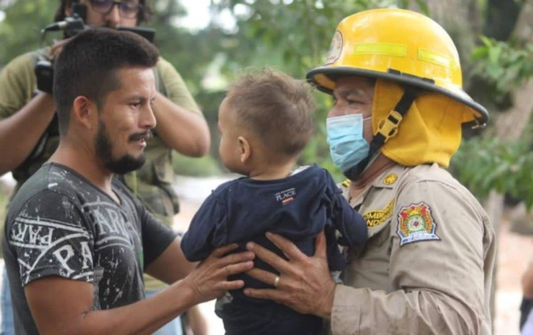 Padres de familia abrazan a sus pequeños tras atravesar con los rescatistas la fuerte corriente de agua.