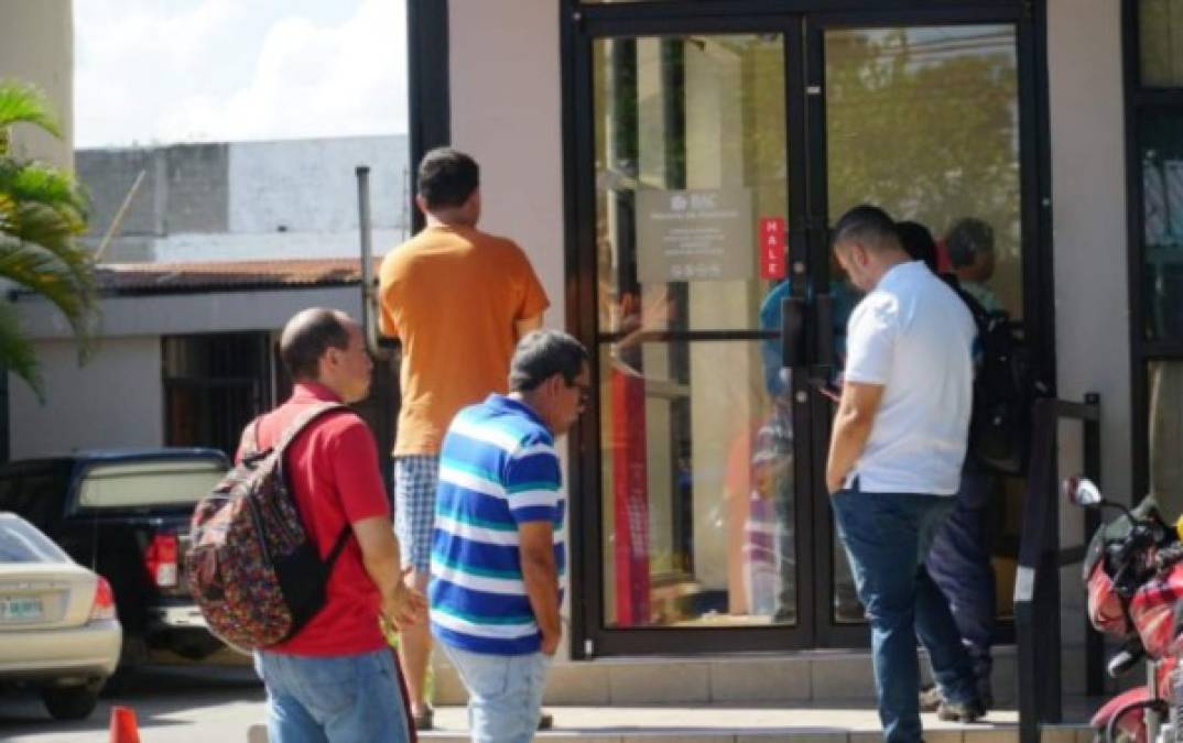 Hondureños hacen fila en un cajero automático en San Pedro Sula.